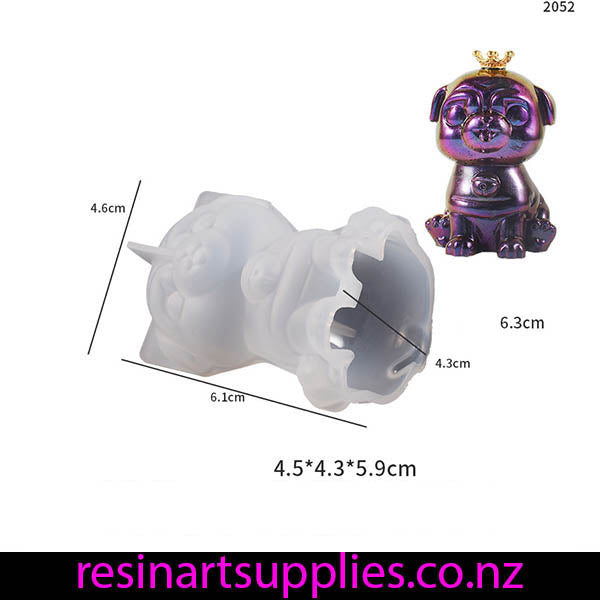 Silicone mold of a dog with measurements and a purple dog figurine on a white background.