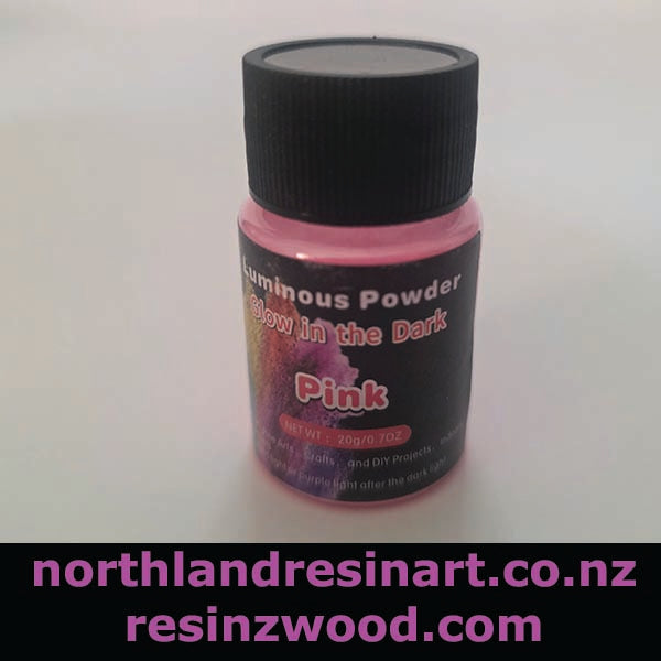 Bottle of pink luminous powder with a black lid on a white background, featuring branding text.