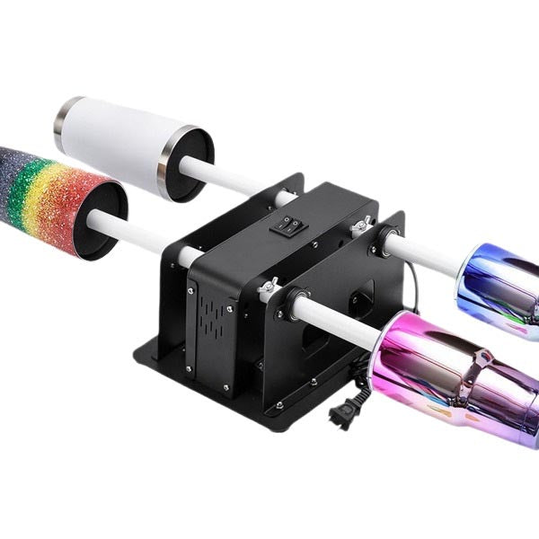 A black four Cup Turner machine with four rotating spools, one showing a rainbow glitter wrap and two showing iridescent metallic pink and blue wraps, on a white background.