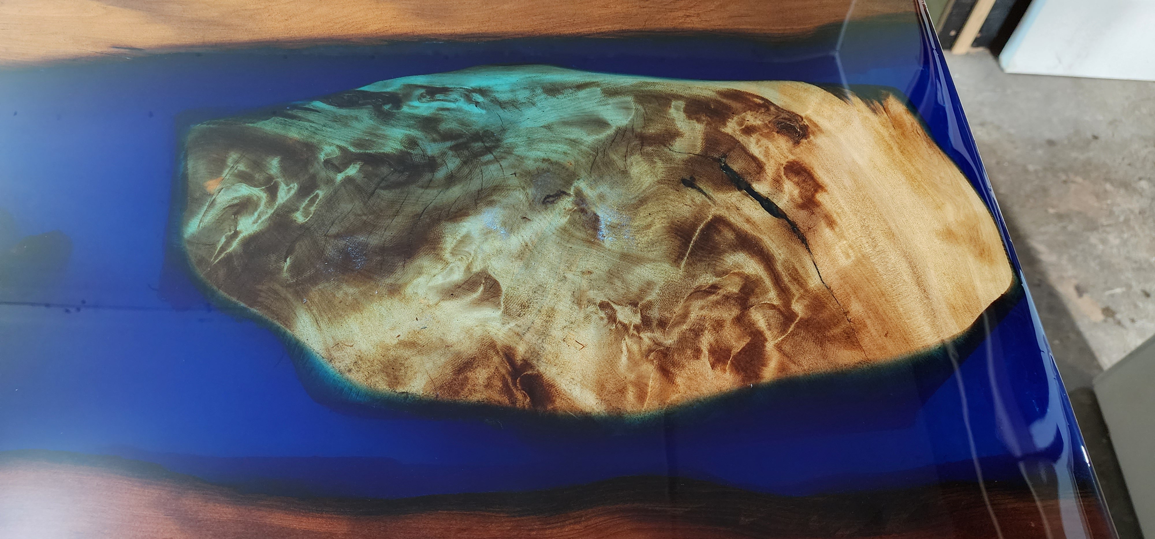 Swamp Kauri timber set in a blue deep pour resin for effect in a river table