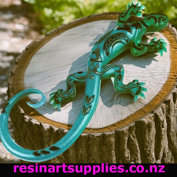 Turquoise resin lizard on a wooden stump with 'resinartsupplies.co.nz' text.