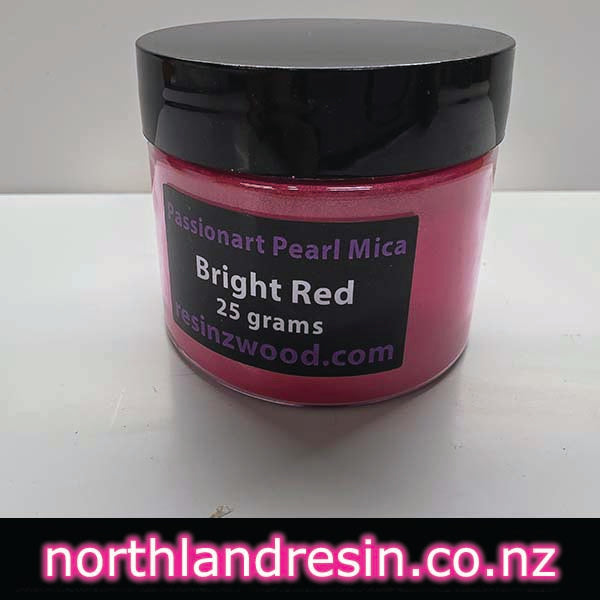 A jar of bright red mica powder on a white background