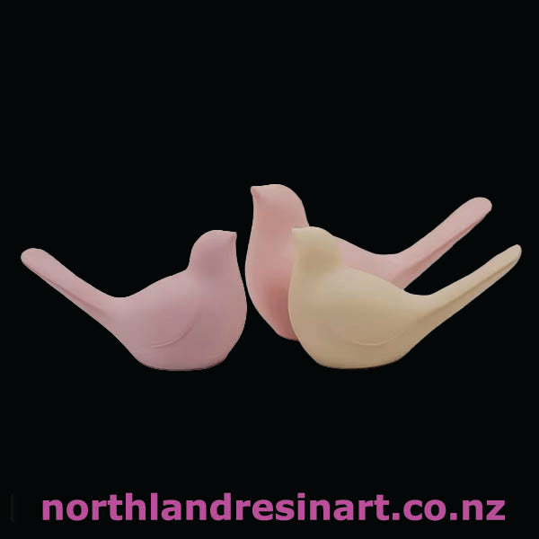 Three bird-shaped objects in pink, purple, and yellow on a black background with 'northlandresinart.co.nz' text.