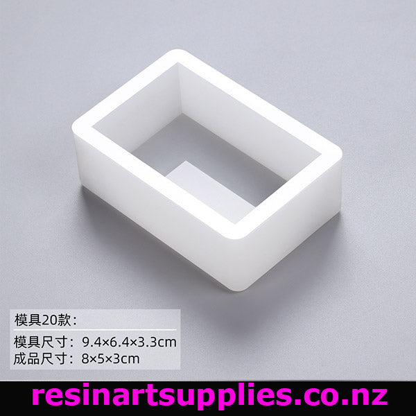 White rectangular plastic mold on a gray background with text and branding.