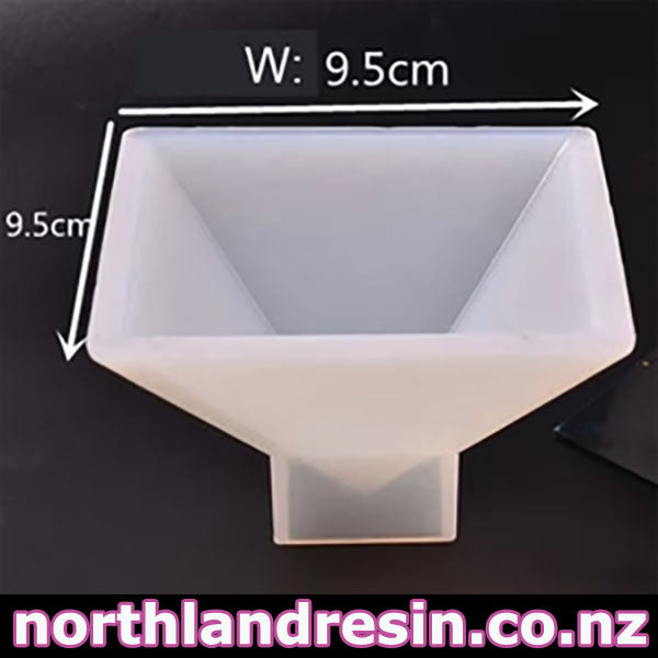 A translucent white pyramid -shaped mold on a dark background with overlaid dimension arrows and text indicating 9.5 cm width and 9.