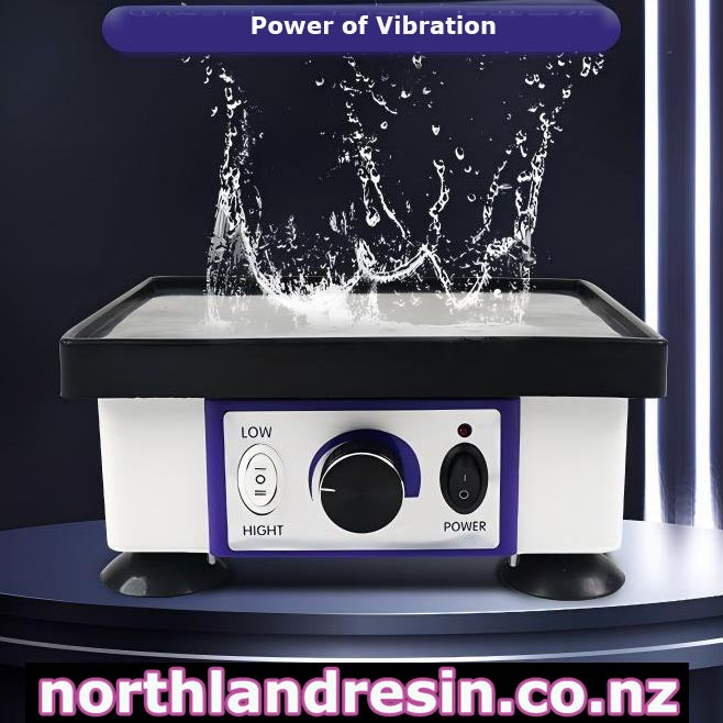A Bubble Remover vibration table with a white body, black top tray, and purple control panel, shown with a water splash effect above the grinding surface. The image includes text overlays reading 'Power of Vibration' and 'northlandresin.