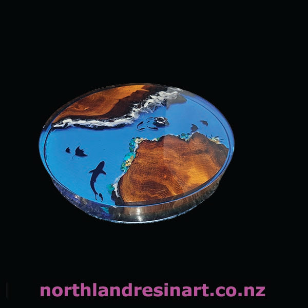 Decorative round table with ocean design and wood finish on a black background